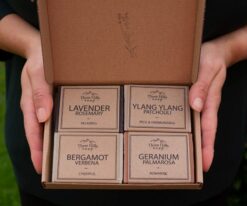 Open gift box with four handmade soaps from Three Hills Soap in labeled rows