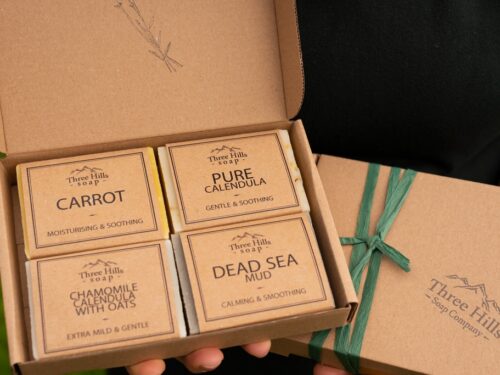 Open soap gift box with four natural bars and green ribbon, from Three Hills Soap