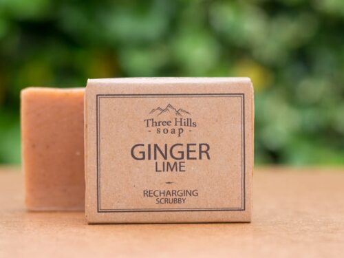 Ginger Lime soap bar with rustic label on light surface and green outdoor background