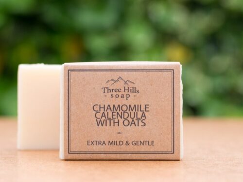 Chamomile Calendula with Oats soap bar with rustic label on light surface and green background