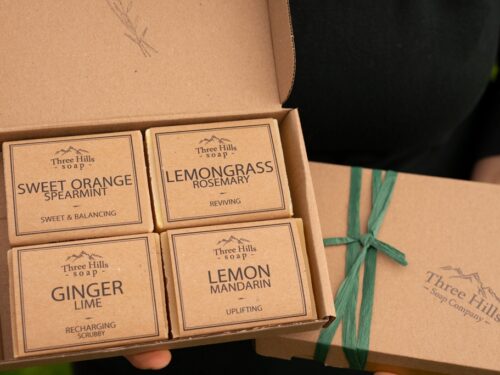 Soap gift set with four citrus-scented bars and green ribbon in kraft box