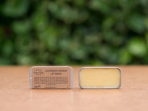 Lavender Orange Lip Balm with rustic label on light surface and green outdoor background