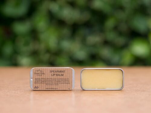 Spearmint Lip Balm with rustic label on light surface and green outdoor background