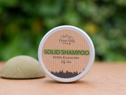 solid shampoo bar for oily hair with rustic label on light surface and green outdoor background