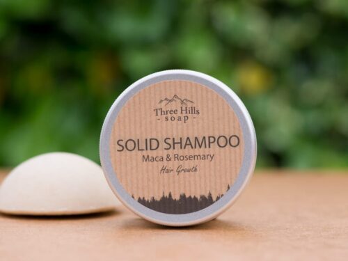 Solid Shampoo bar for hair growth with rustic label on light surface and green outdoor background