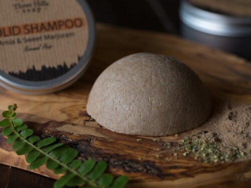 Solid Shampoo bar for normal hair on the wooden surface with a black background