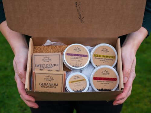 Natural soap and bath salts in rustic tray with warm, serene lighting