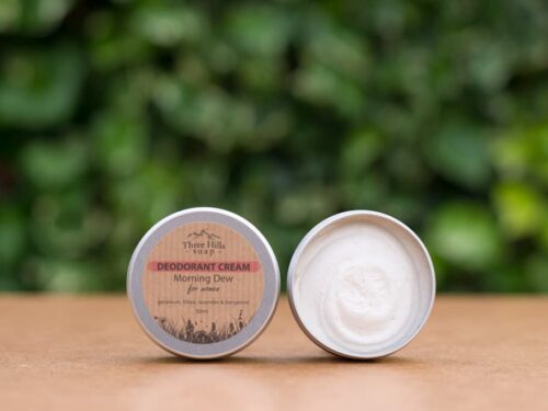 Morning Dew deodorant cream tin open with greenery in background