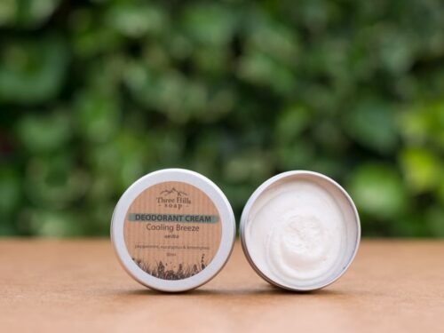 Deodorant Cream Cooling Breeze with rustic label on light surface and green outdoor background