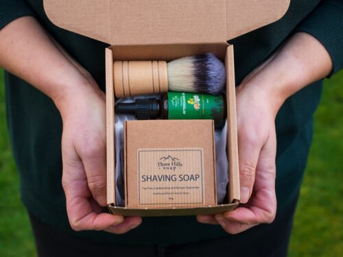 Shaving gift set with natural soap and wooden-handled brush in kraft packaging