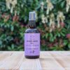 Three Hills Soap Organic Grapeseed Oil in 100ml amber bottle with pump, placed on wood with green outdoor background