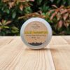 A travel shampoo bar for all hair types in the tin on the wooden surface.