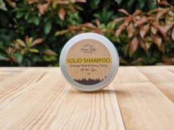 A travel shampoo bar for all hair types in the tin on the wooden surface.