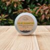 A travel shampoo bar for all hair types in the tin on the wooden surface.