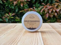 A travel shampoo bar for hair growth in the tin on the wooden surface.