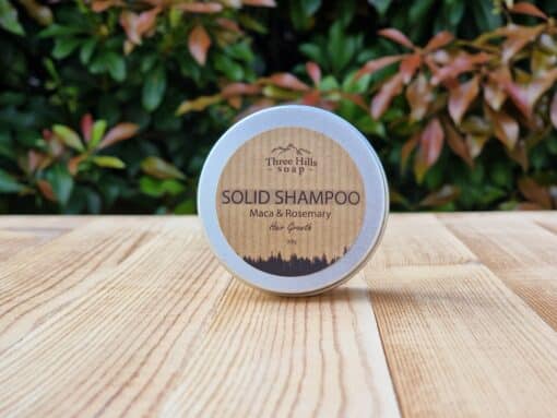 A travel shampoo bar for hair growth in the tin on the wooden surface.