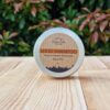 A travel shampoo bar for normal hair in the tin on the wooden surface.