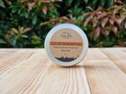 A travel shampoo bar for normal hair in the tin on the wooden surface.
