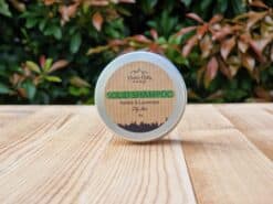 A travel shampoo bar for oily hair in the tin on the wooden surface.